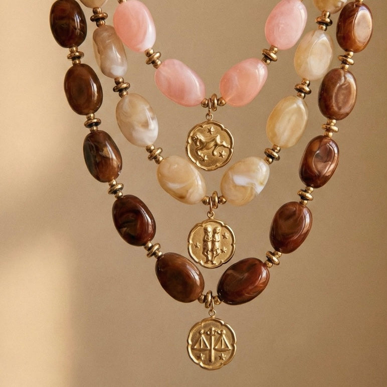 collier perles résine et breloque astro